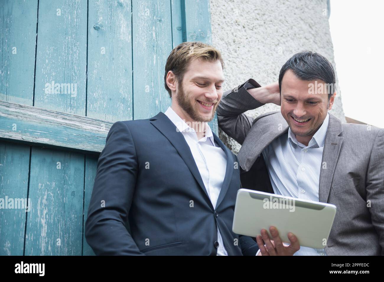 Two businessmen using digital tablet outside, Bavaria, Germany Stock Photo