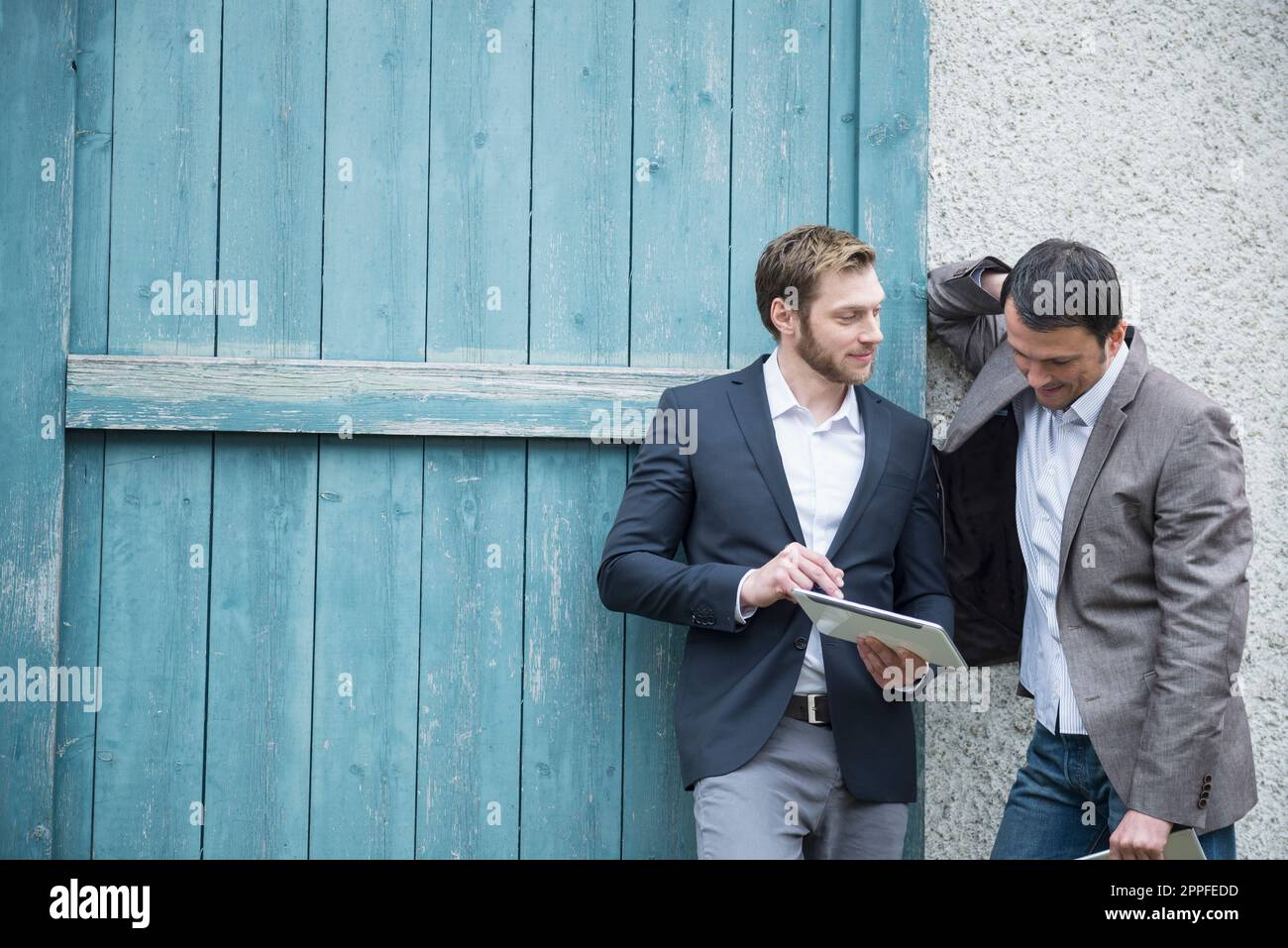 Two businessmen using digital tablet outside, Bavaria, Germany Stock Photo