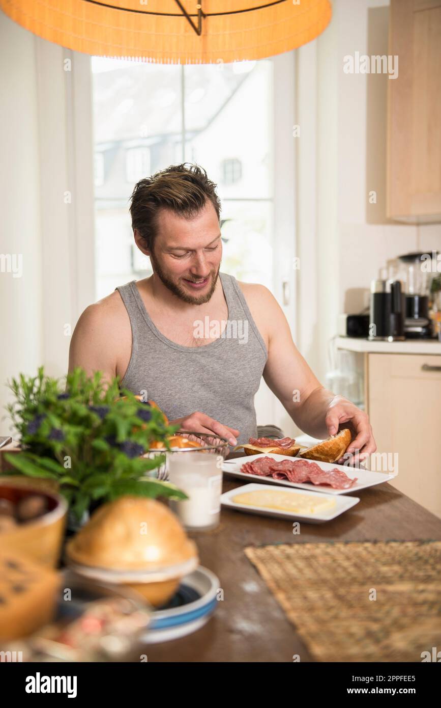 Man preparing breakfast in the kitchen, Munich, Bavaria, Germany Stock Photo