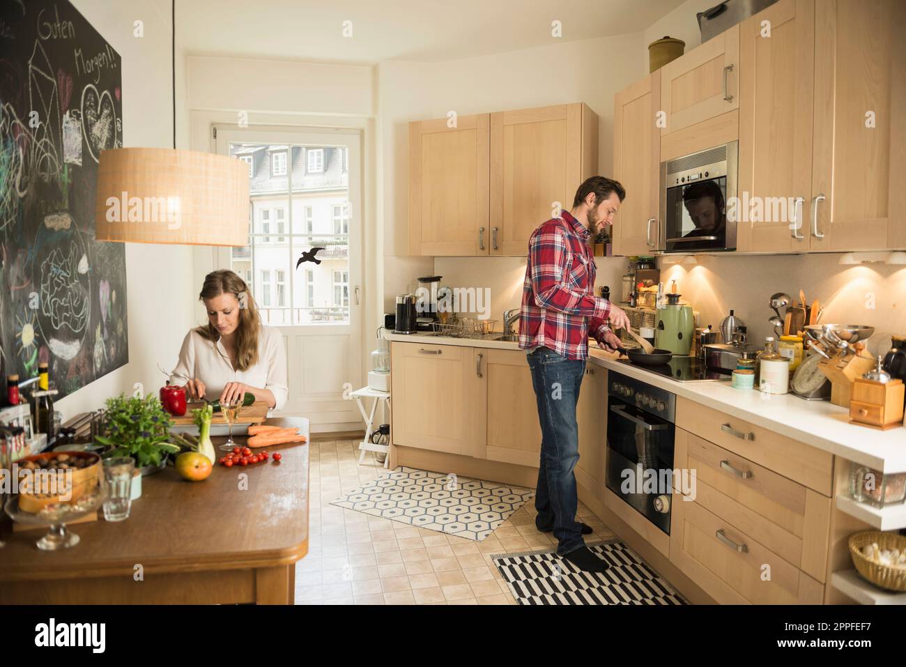 Couple in kitchen and preparing food, Munich, Bavaria, Germany Stock Photo