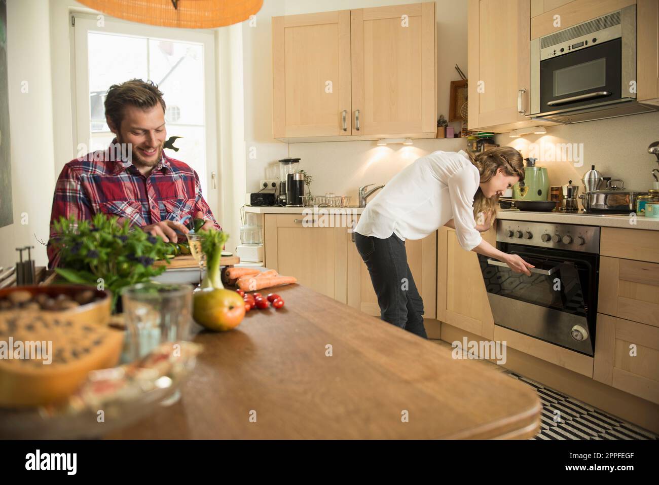 Couple in kitchen preparing food, Munich, Bavaria, Germany Stock Photo