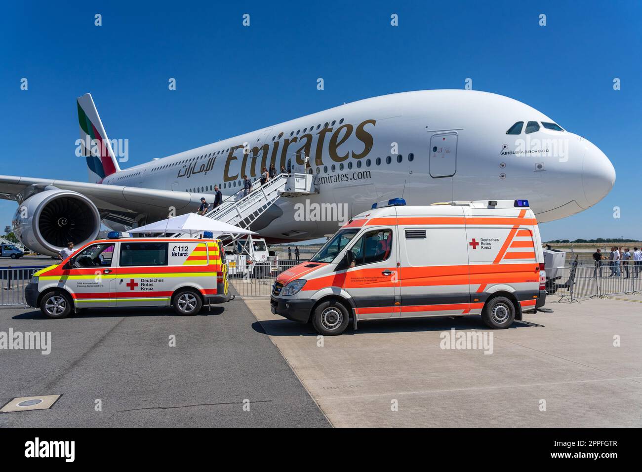BERLIN, GERMANY - JUNE 23, 2022: Two ambulances in front of the largest passenger airliner in the world - Airbus A380-800. Emirates Airline. Exhibition ILA Berlin Air Show 2022 Stock Photo