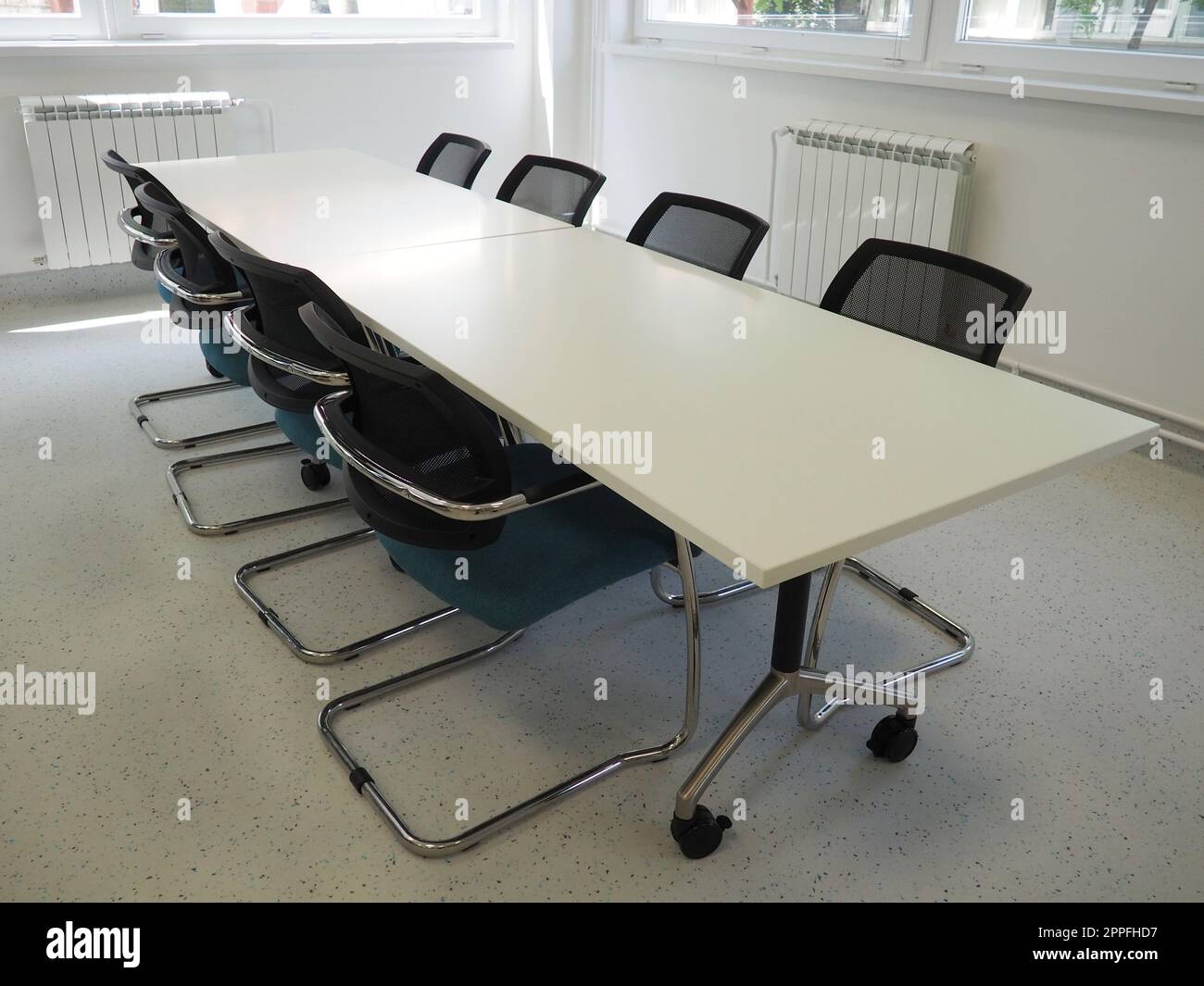 table and chairs in the meeting room or in the auditorium. Library, office, or premises in an official institution or bank. There is no one at the table. White, black and gray paints in the interior Stock Photo