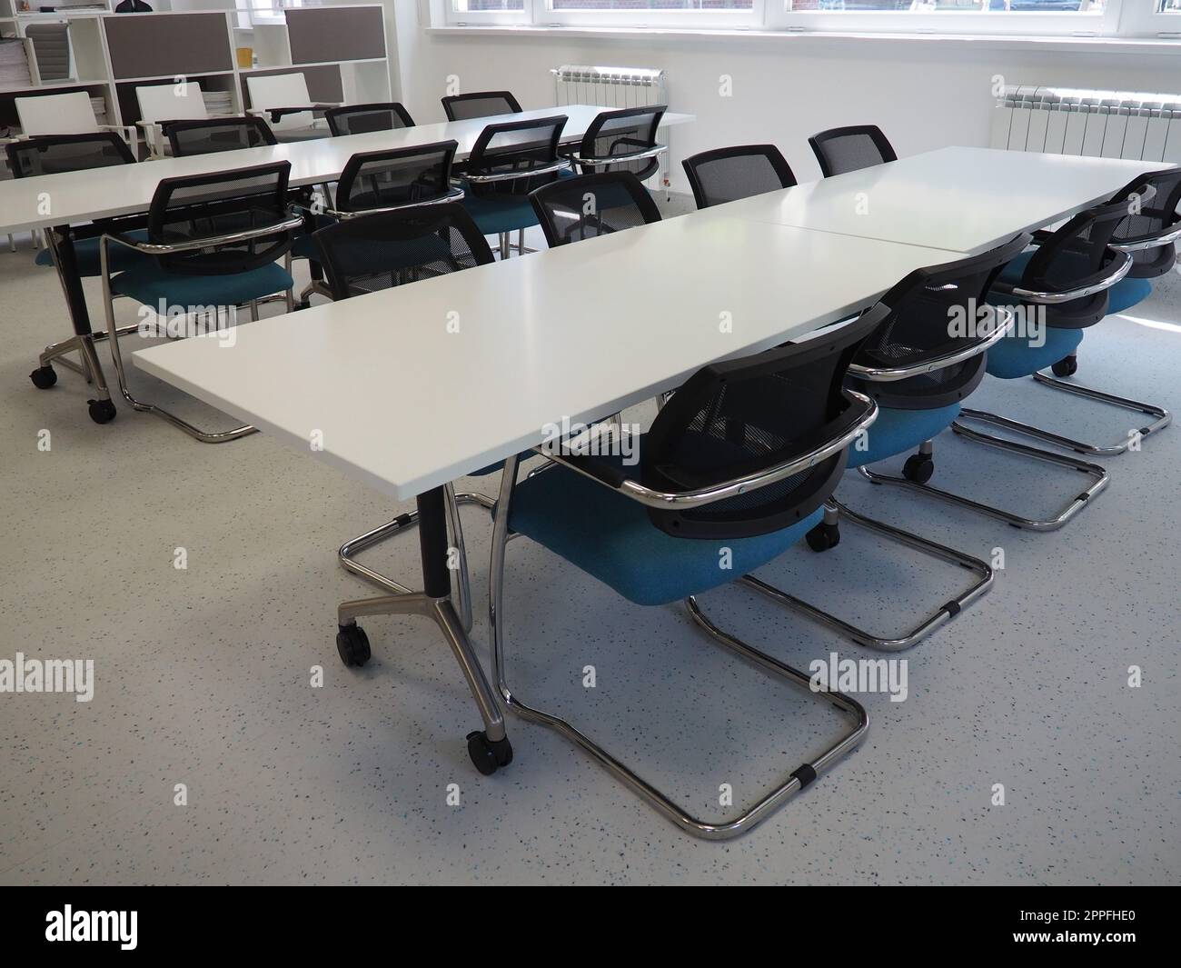 table and chairs in the meeting room or in the auditorium. Library, office, or premises in an official institution or bank. There is no one at the table. White, black and gray paints in the interior Stock Photo
