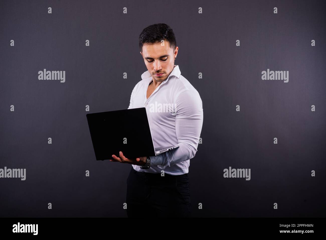 Cheerful young guy 20s in classic shirt isolated on dark wall background studio portrait. Stock Photo