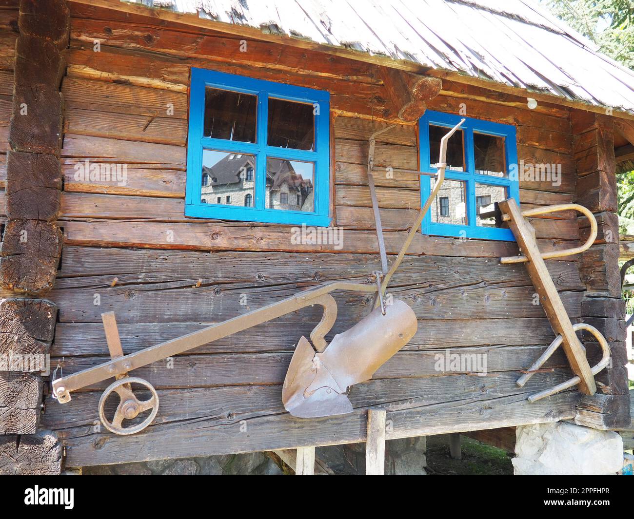 Stanisici, Bijelina, Bosnia and Herzegovina, 25 April 2021. Log village farmhouse. 19th century Bosnian mountain traditional dwelling. Restored ethno building, implements of agricultural labor. Stock Photo