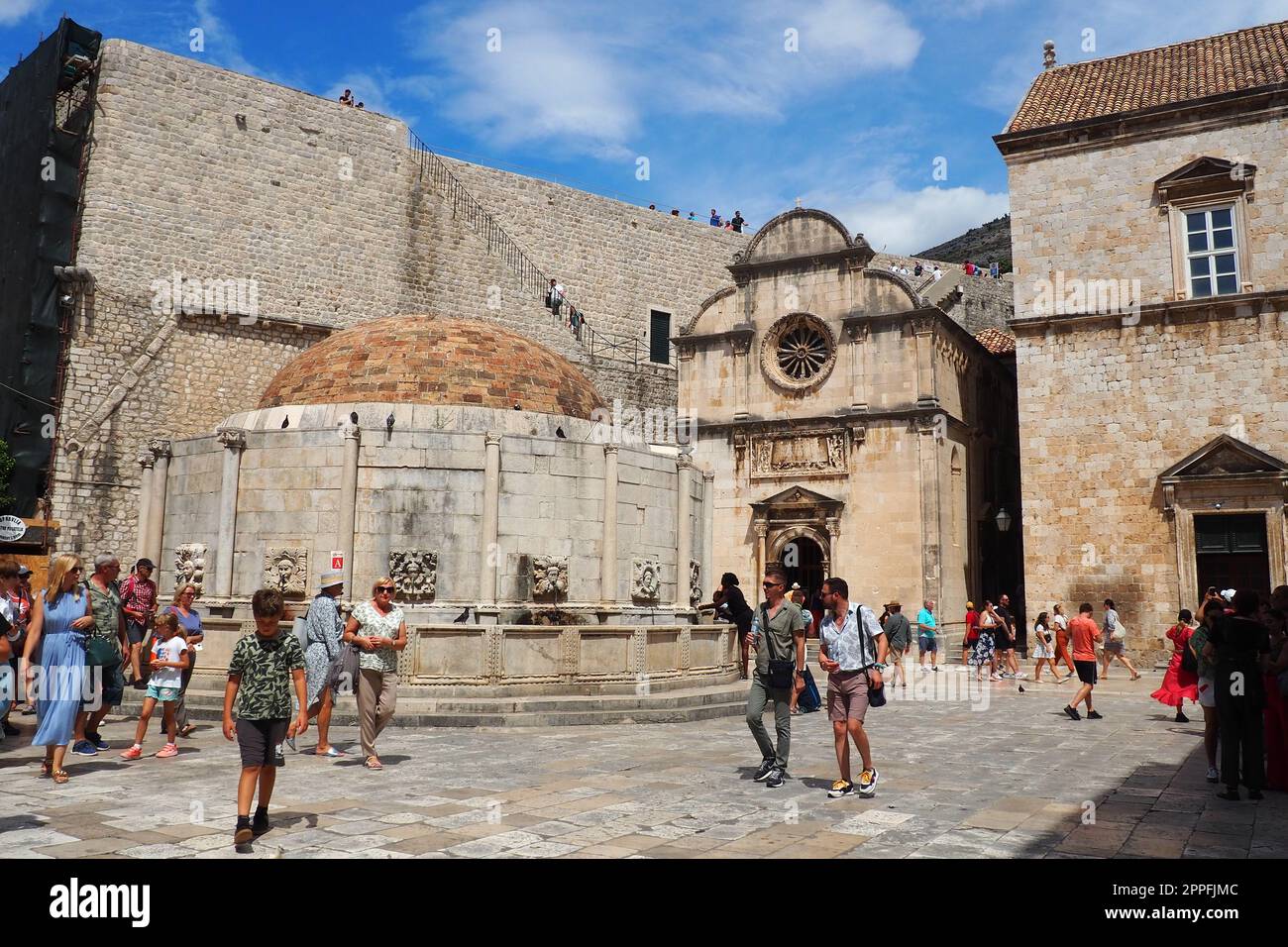 Dubrovnik, Croatia, 08.14.2022. Big fountain of Onofrio. A mascaron, a decorative element in the form of a mask of a mythological character. High relief or sculpture. People and tourists Stock Photo