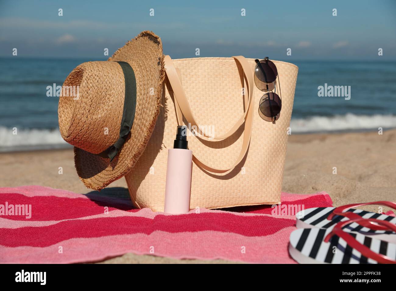 Straw hat, bag and other beach items on sandy seashore Stock Photo - Alamy