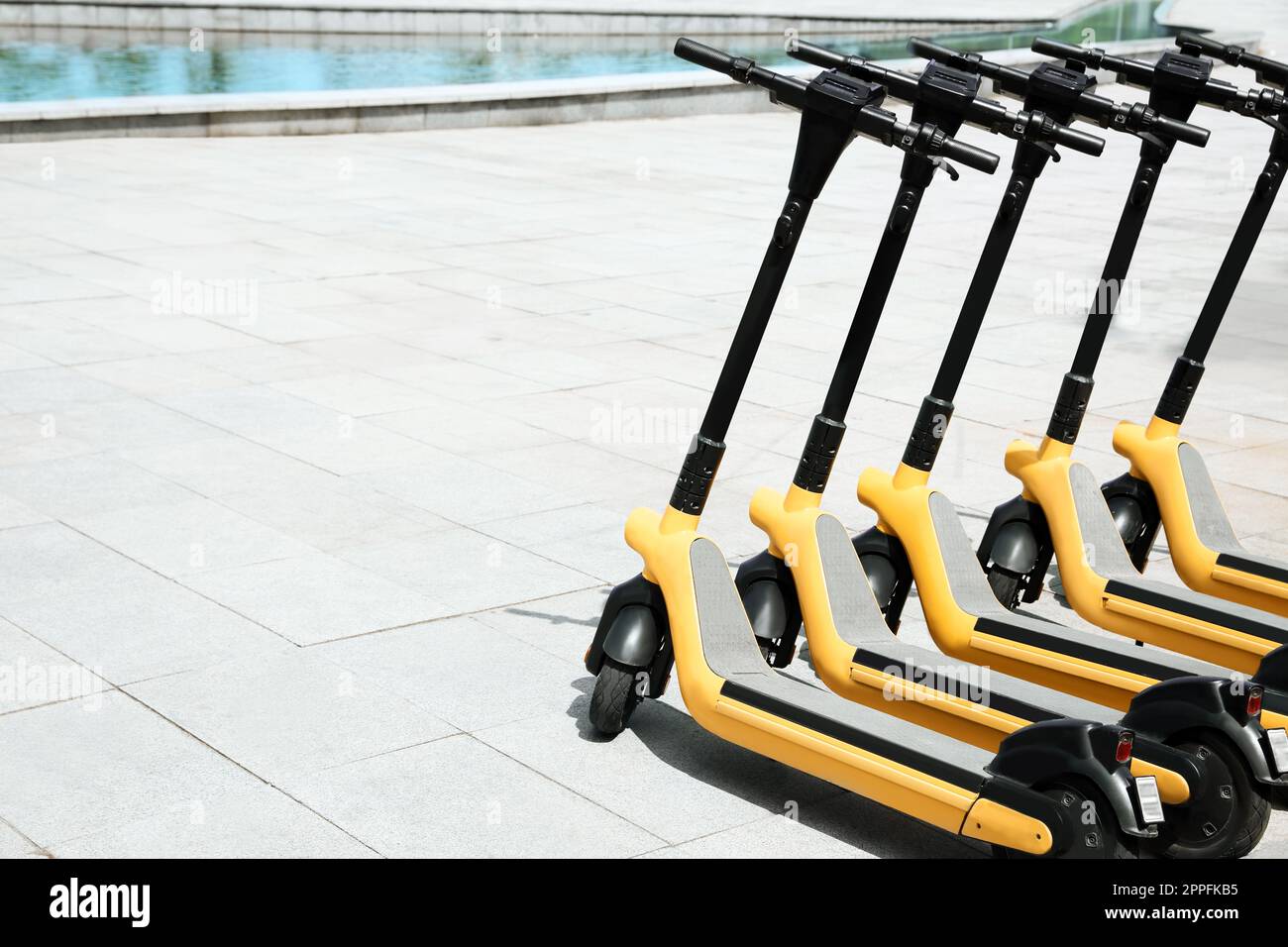 Many modern electric scooters outdoors, space for text. Rental service ... - Modern Electric Scooters
