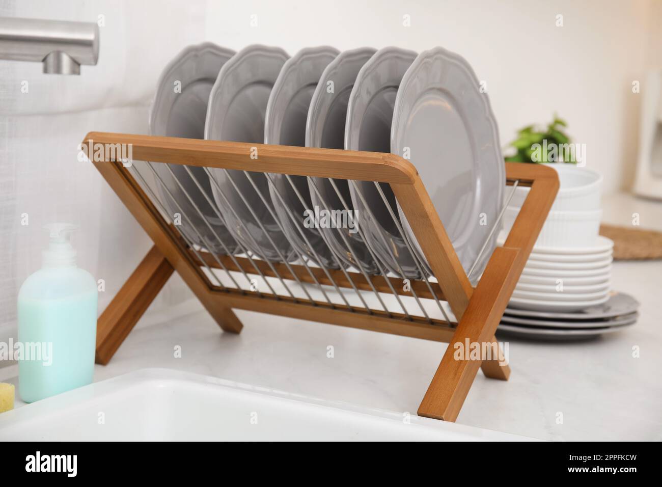 Clean dishes on wooden drying rack in stylish kitchen Stock Photo Alamy