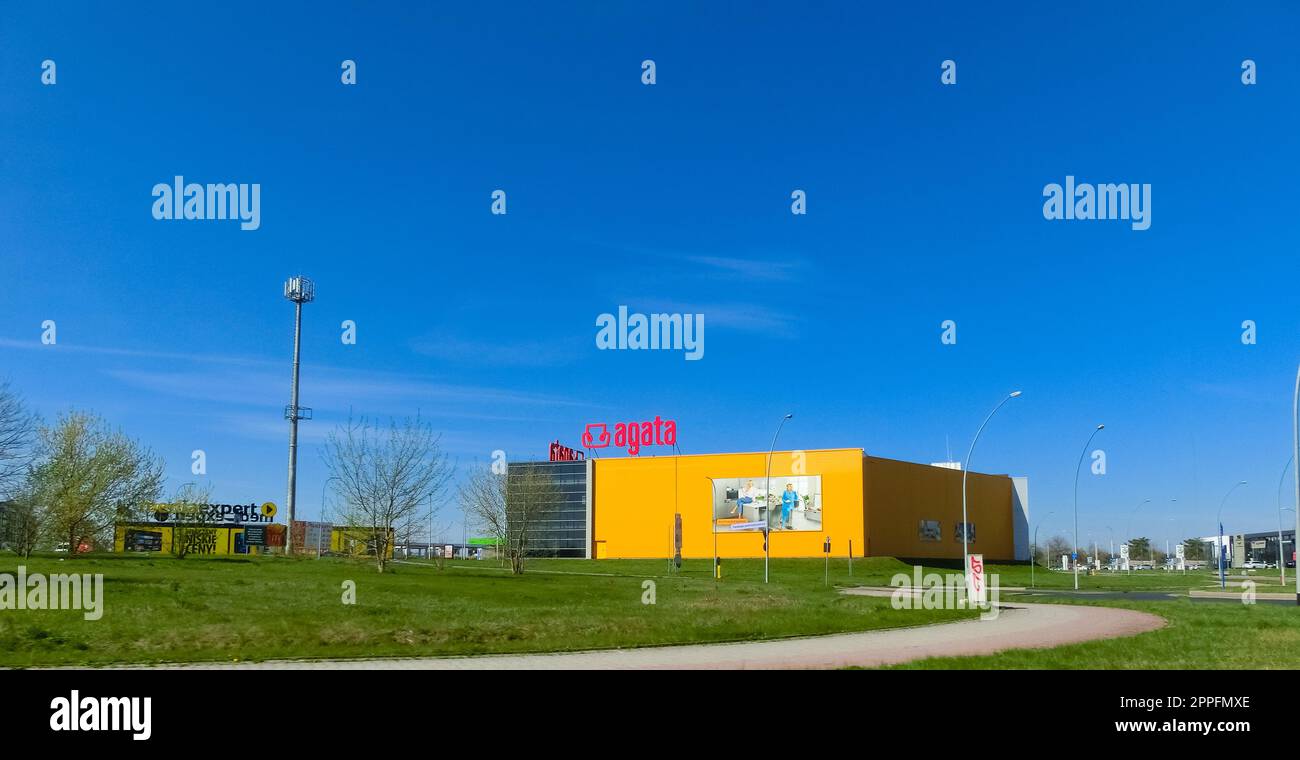 Logo of the Agata Meble furniture store with an advertisement banner on the yellow wall Stock Photo