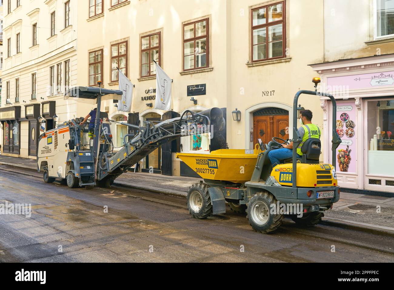 Workers in the center of Vienna in the Seilergasse during milling work to renew the asphalt of a street Stock Photo
