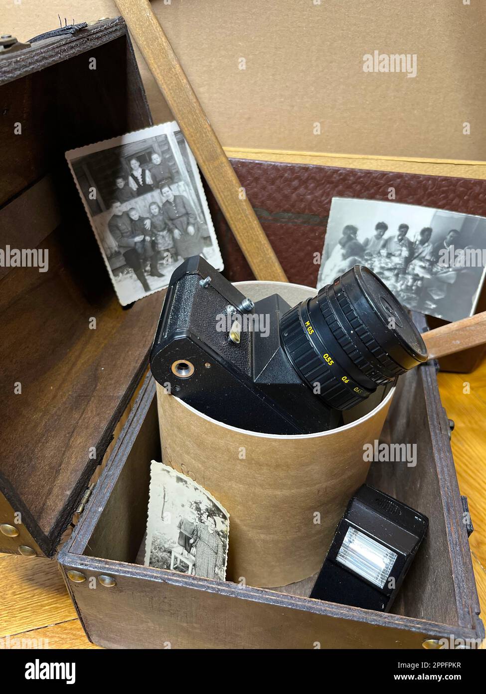 an old SLR camera in a frame and in a chest Stock Photo