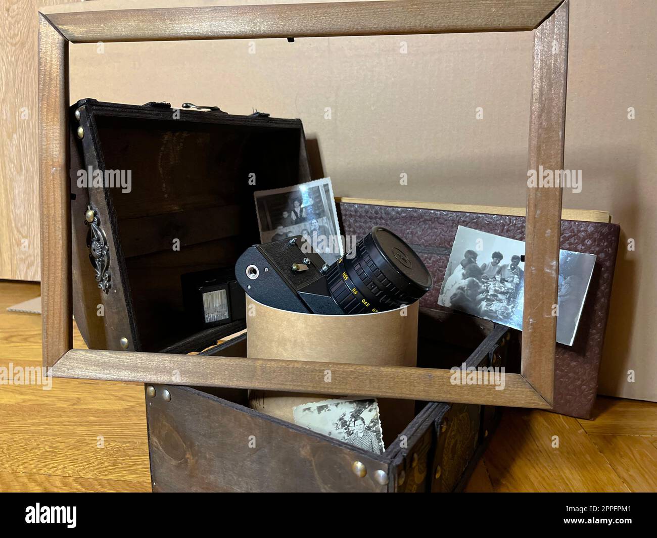 an old SLR camera in a frame and in a chest Stock Photo