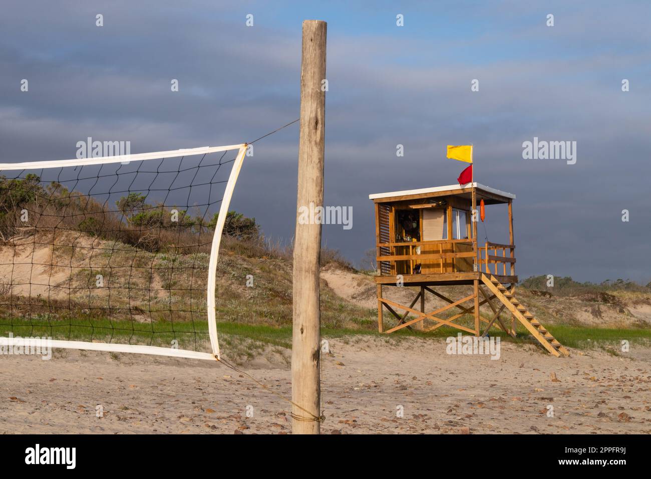 lifeguard tower next to a volleyball court on a windy day Stock Photo