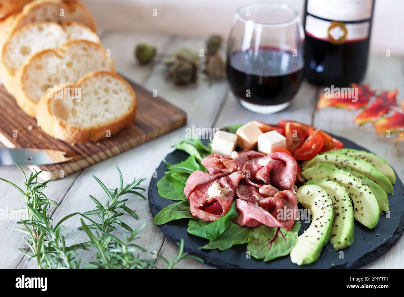 Roast beef and avocado hors d'oeuvre snacks and red wine Stock Photo
