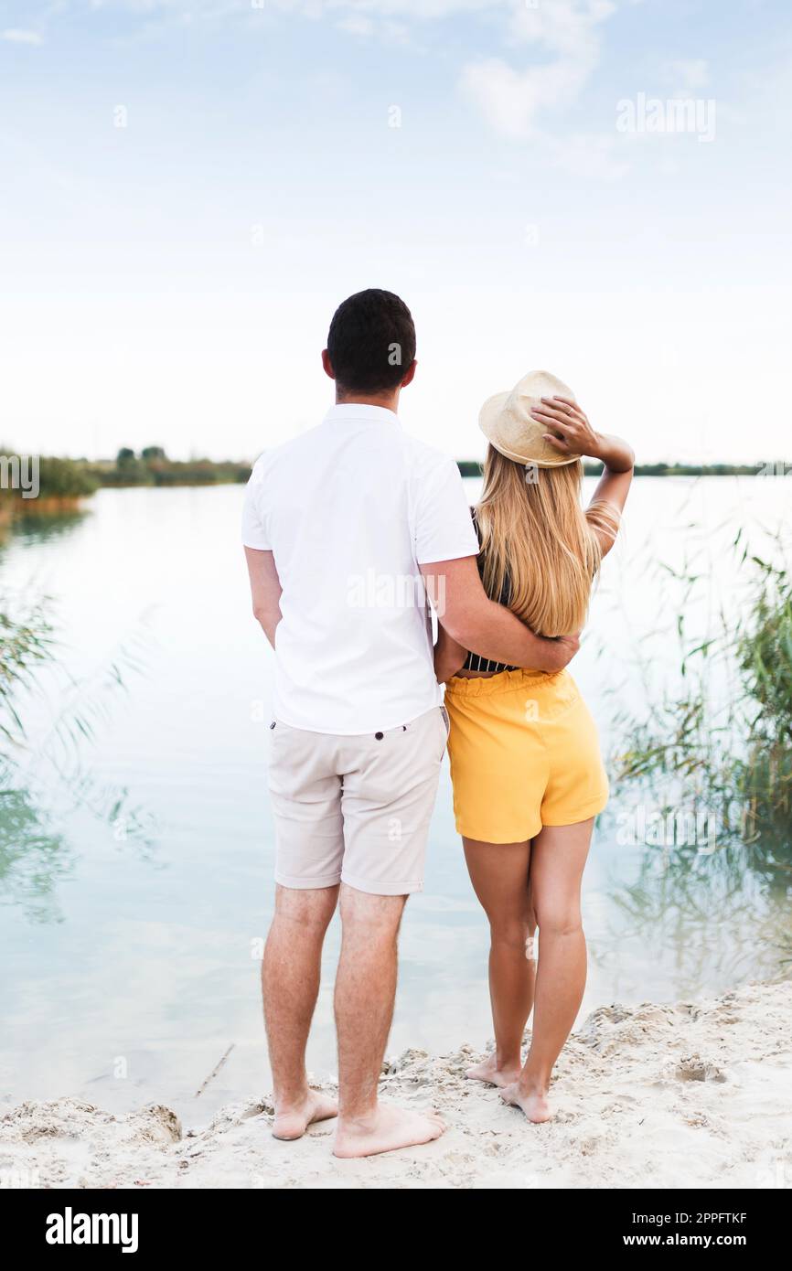 man and a woman on the beach are hugging around the water Stock Photo ...