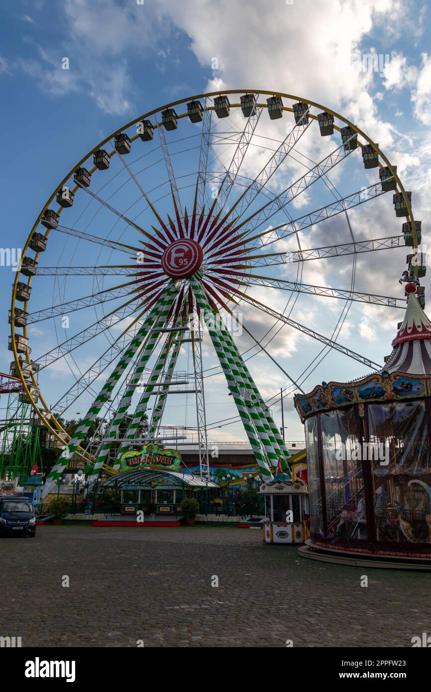 DÃ¼sseldorf, NRW, Germany - 07 14 2022: Big ferris wheel with Fortuna 95 logo as thrilling fun ride on the DÃ¼sseldorfer Rheinkirmes amusement park as big parish fair and kermis Germany for F95 fans Stock Photo