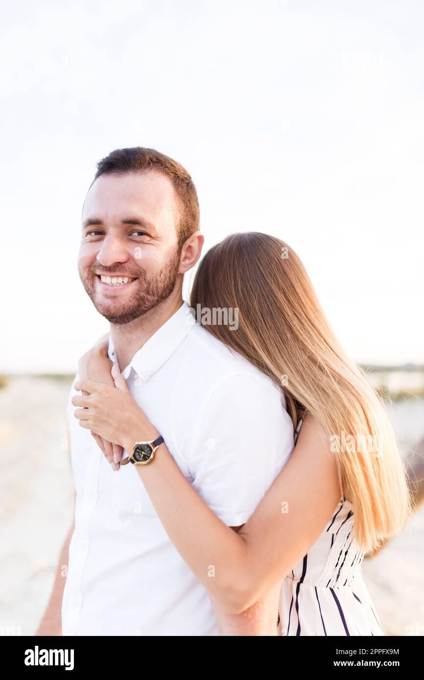 man and a woman are hugging on a sandy beach in summer Stock Photo - Alamy