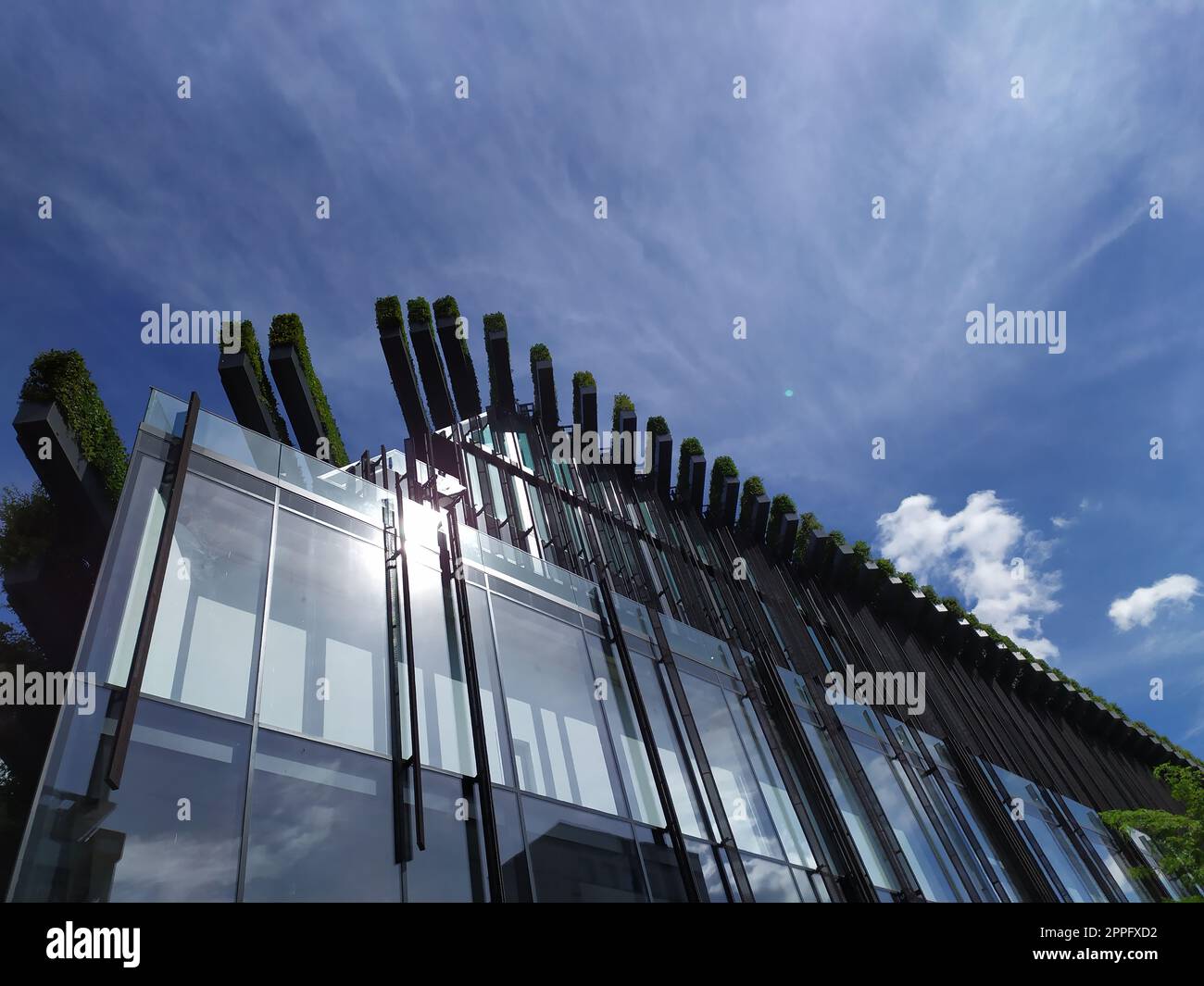 Dusseldorf, Germany - July 16th, 2022: Modern architecture of the DÃ¼sseldorfer KÃ¶bogen in summer shows attractive and extravagant glass facade of organic and curvy shopping mall with blue sky clouds Stock Photo