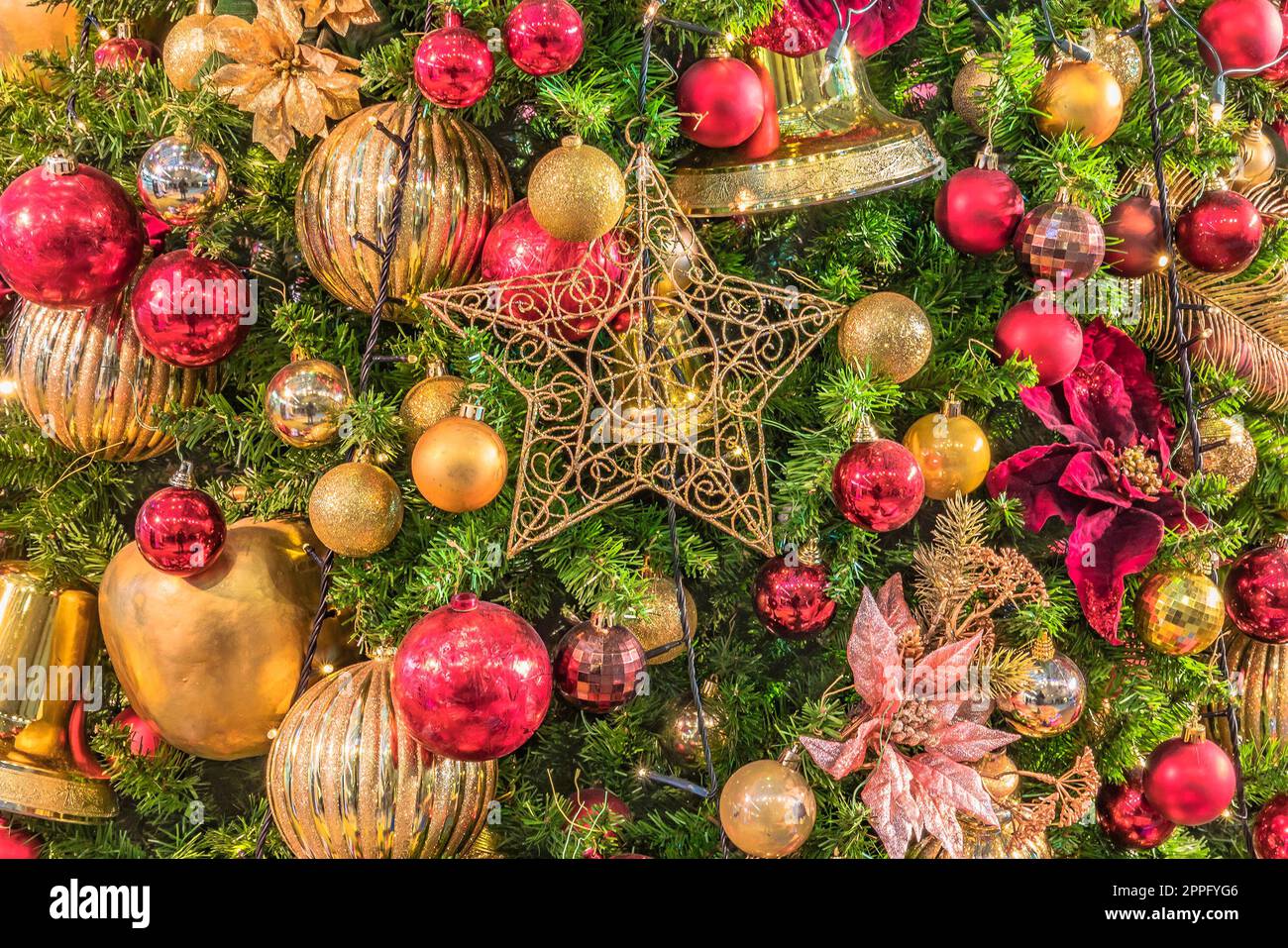 Background of Christmas tree ornament lights with glitter decoration balls in foreground. Stock Photo
