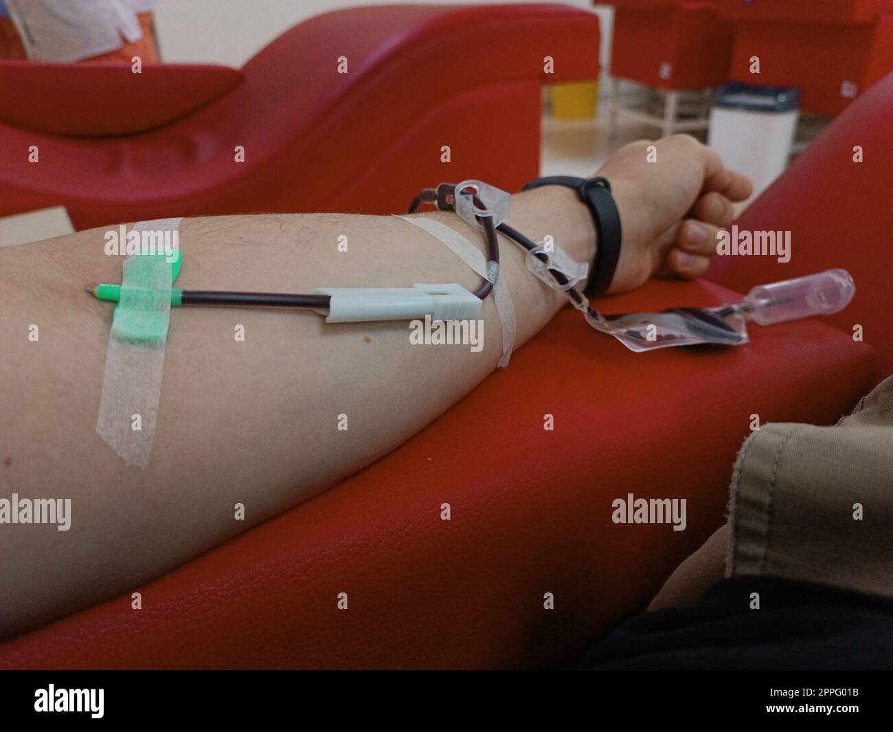 Blood donation, blood transfusion, check specified, fasting, health care. Left arm of caucasian young man with equipment for blood or plasma donations in donation centre. Blood donation concept. Plasma donation concept. Save life concept. Stock Photo