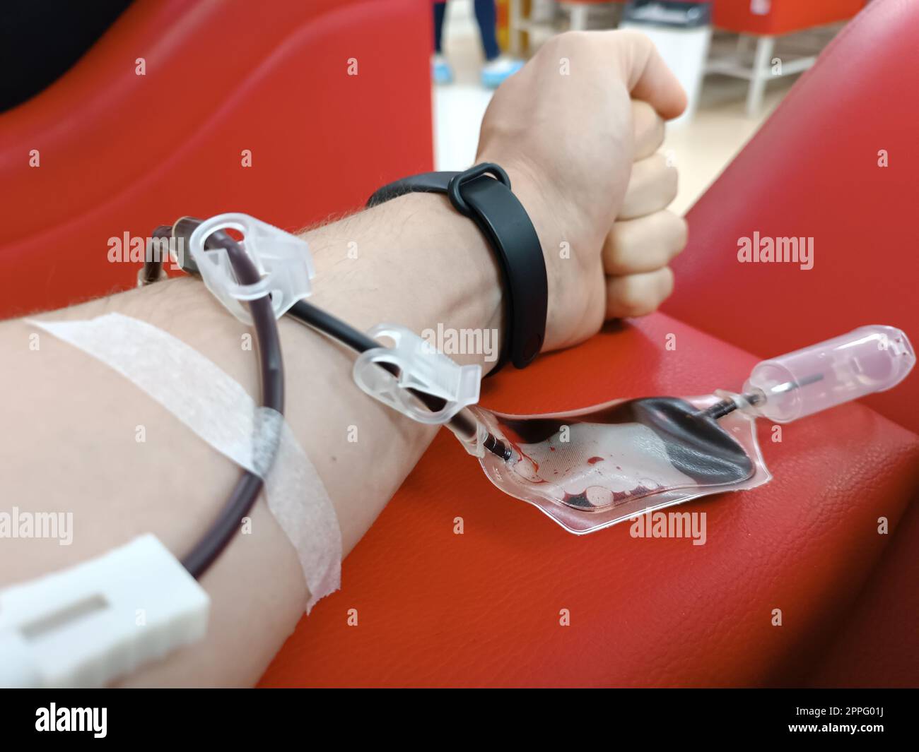 Blood donation, blood transfusion, check specified, fasting, health care. Left arm of caucasian young man with equipment for blood or plasma donations in donation centre. Blood donation concept. Plasma donation concept. Save life concept. Stock Photo