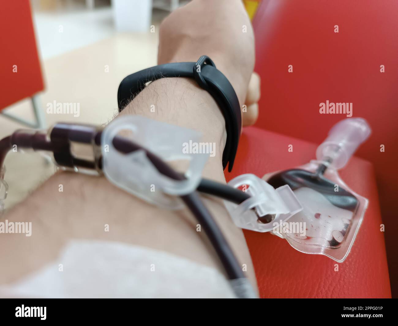 Blood donation, blood transfusion, check specified, fasting, health care. Left arm of caucasian young man with equipment for blood or plasma donations in donation centre. Blood donation concept. Plasma donation concept. Save life concept. Stock Photo