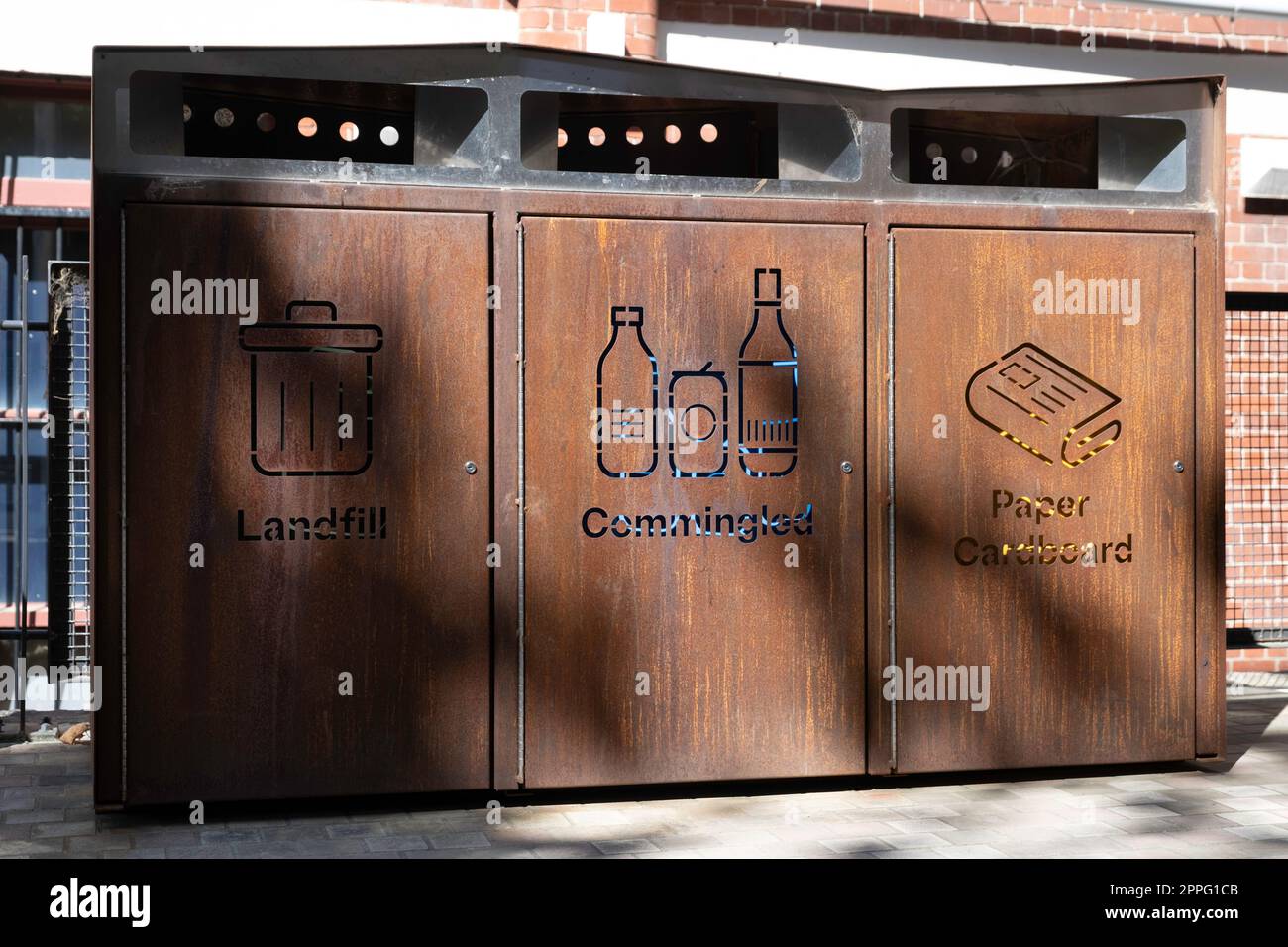 Garbage cans made of rusted Corten steel with separate bins for paper
