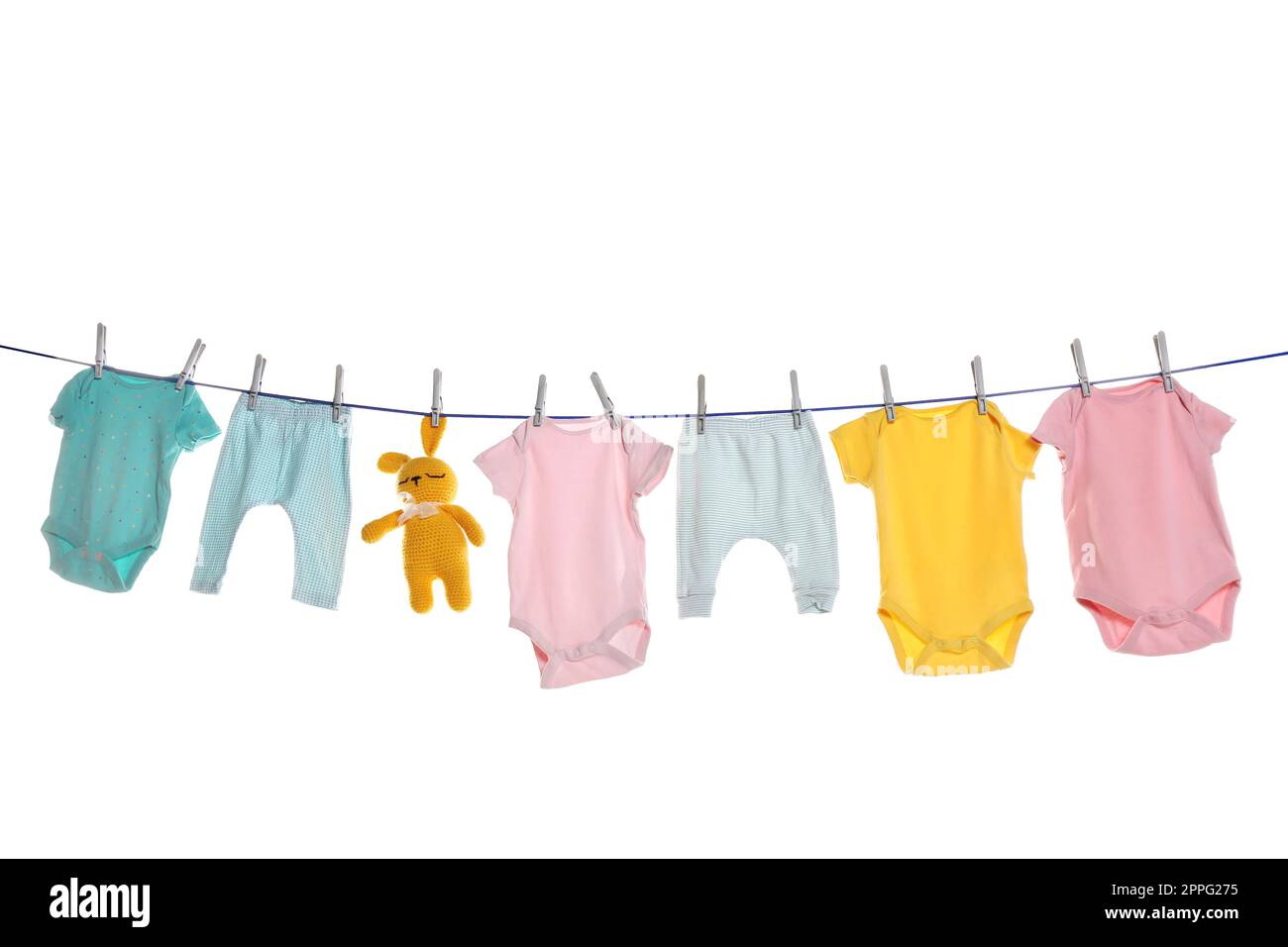 Colorful baby clothes and toy drying on laundry line against white