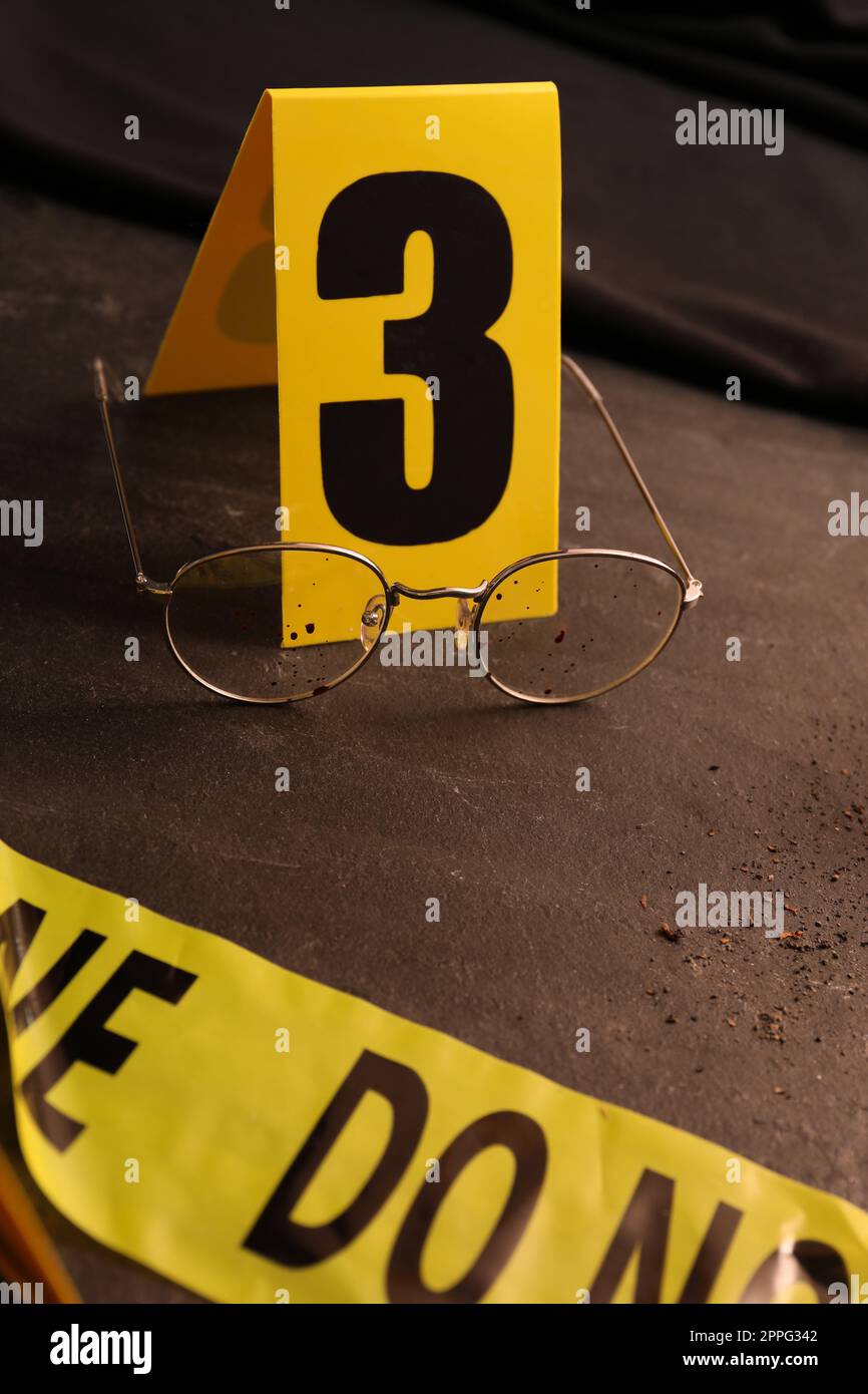 Crime scene marker and glasses on black slate table Stock Photo - Alamy
