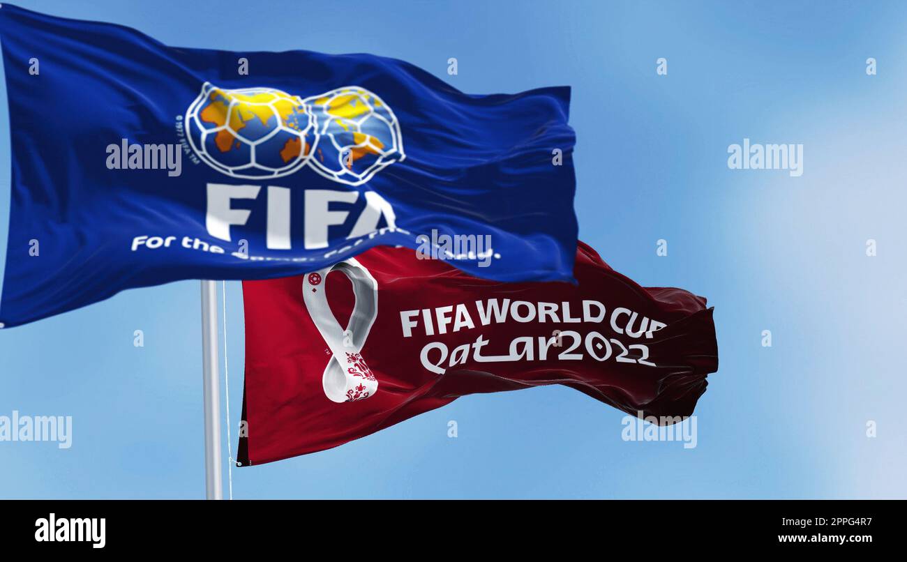 Flags with FIFA and Qatar 2022 World Cup logo waving in the wind Stock Photo