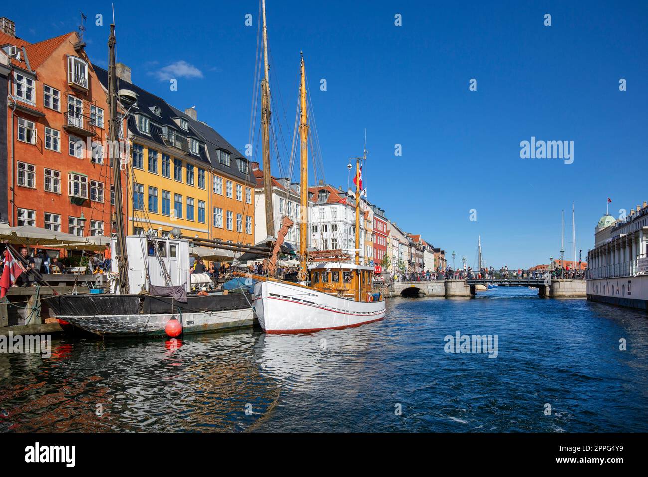 Colorfur houses on the canal in Nyhavn, ships moored at the waterfront, Copenhagen, Denmark Stock Photo