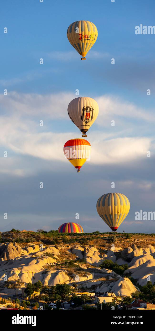 group of hot air balloons fly near Goreme at sunrise. Stock Photo
