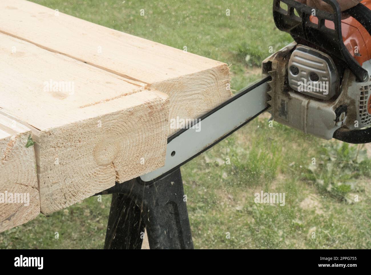 Constructor worker cutting planks with chainsaw Stock Photo