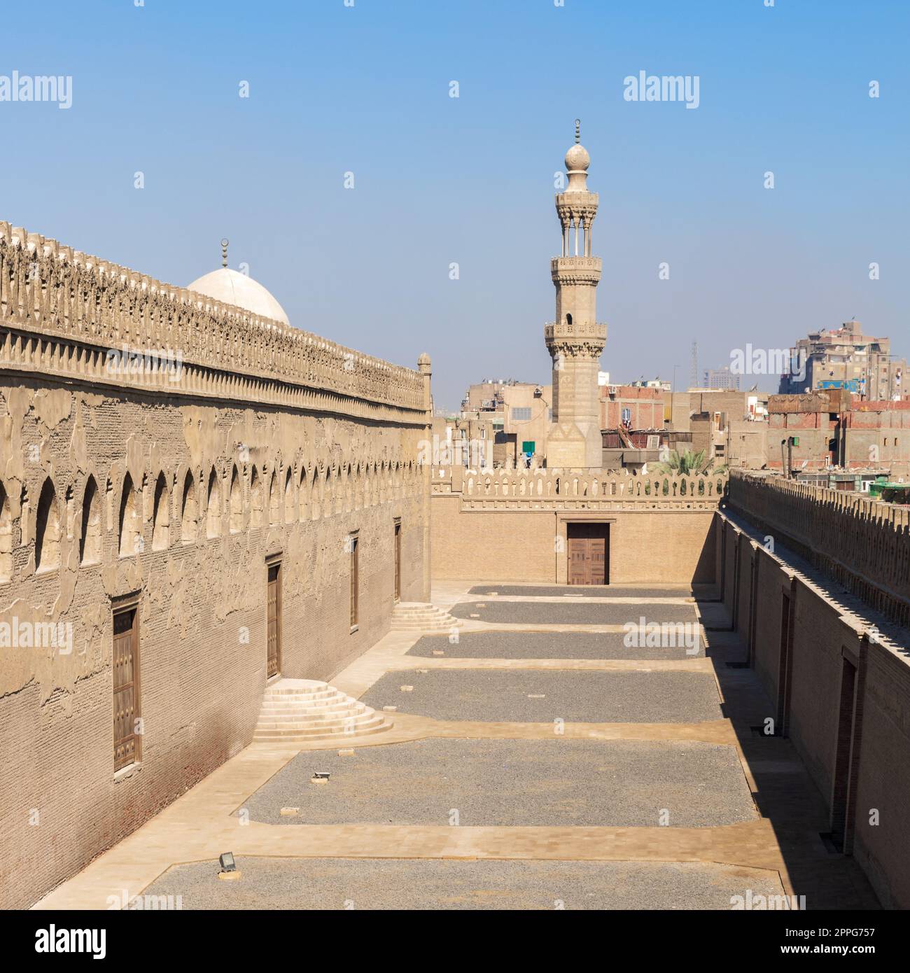Passages outside Ibn Tulun mosque with the minaret of Amir Sarghatmish mosque at far distance, Cairo, Egypt Stock Photo