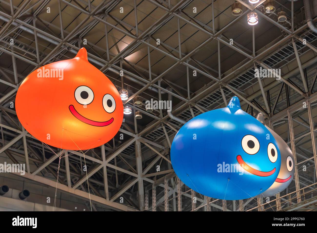 chiba, japan - december 22 2018:  Huge inflatable balloons depicting Slime, the mascot of the Dragon Quest role-playing video game floating under the ceiling of the anime convention Jump Festa 19. Stock Photo