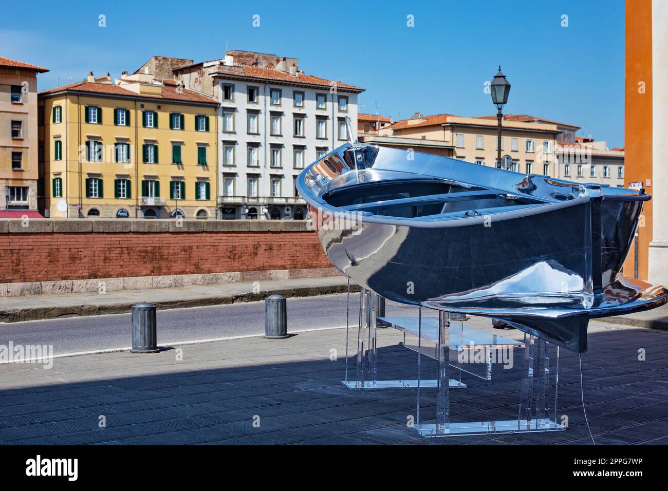 Boat with mirror silver surface near the Santa Cristina Roman Catholic church in Pisa. Stock Photo