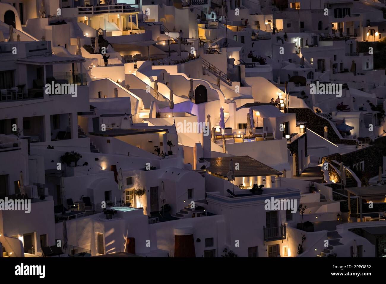 Illuminated whitewashed houses with terraces and pools and a beautiful view in Imerovigli on Santorini island Stock Photo