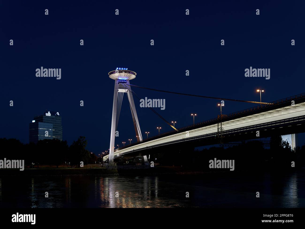 The bridge of the Slovak National Uprising in Bratislava SNP over the Danube River in the evening with a restaurant at a great height Stock Photo