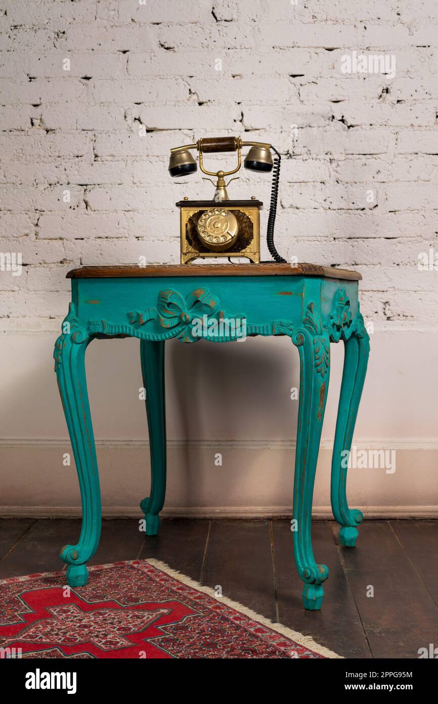 Green vintage wooden table and old golden telephone set Stock Photo