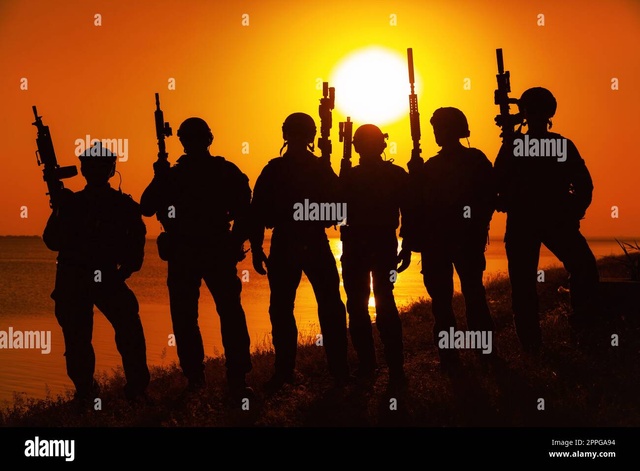 Army soldiers with rifles orange sunset silhouette Stock Photo