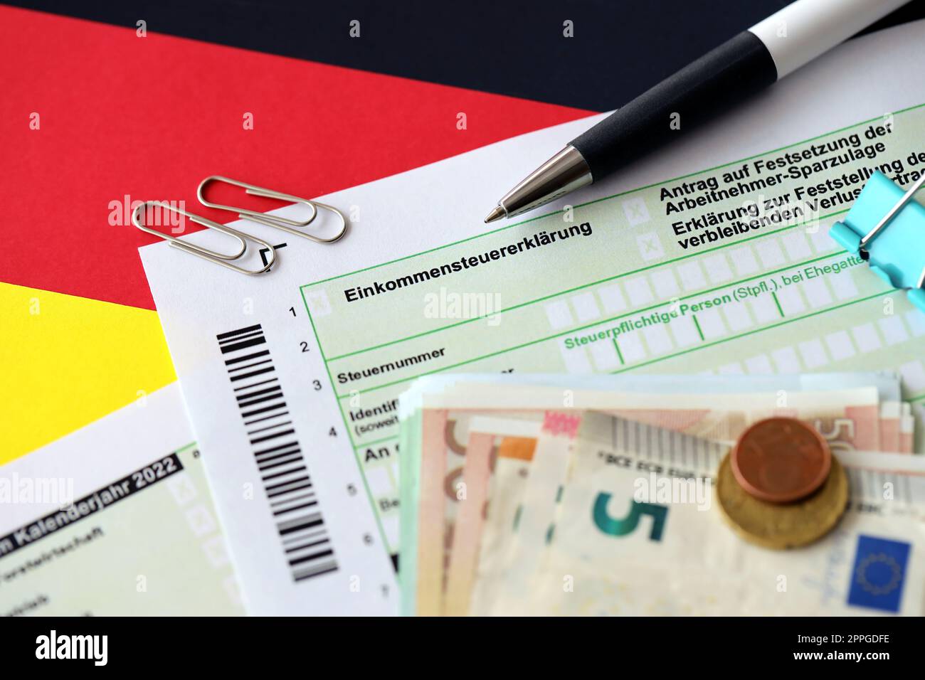German tax return form with pen and european euro money bills lies on flag close up