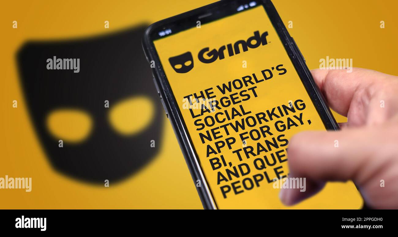 hand holding a phone with Grindr mobile application on screen Stock