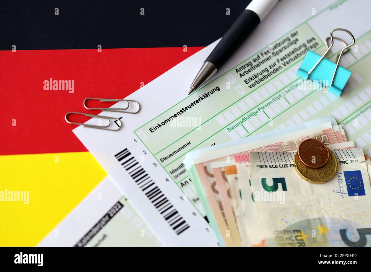 German tax return form with pen and european euro money bills lies on flag close up
