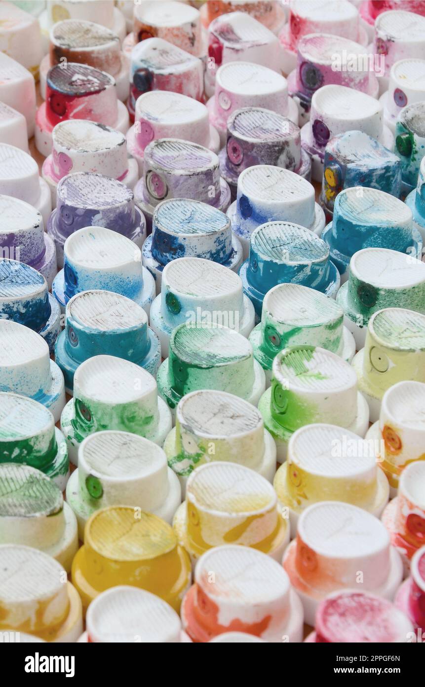 A pattern from a many nozzles from a paint sprayer for drawing graffiti, smeared into different colors. The plastic caps are arranged in many rows forming the color of the rainbow Stock Photo
