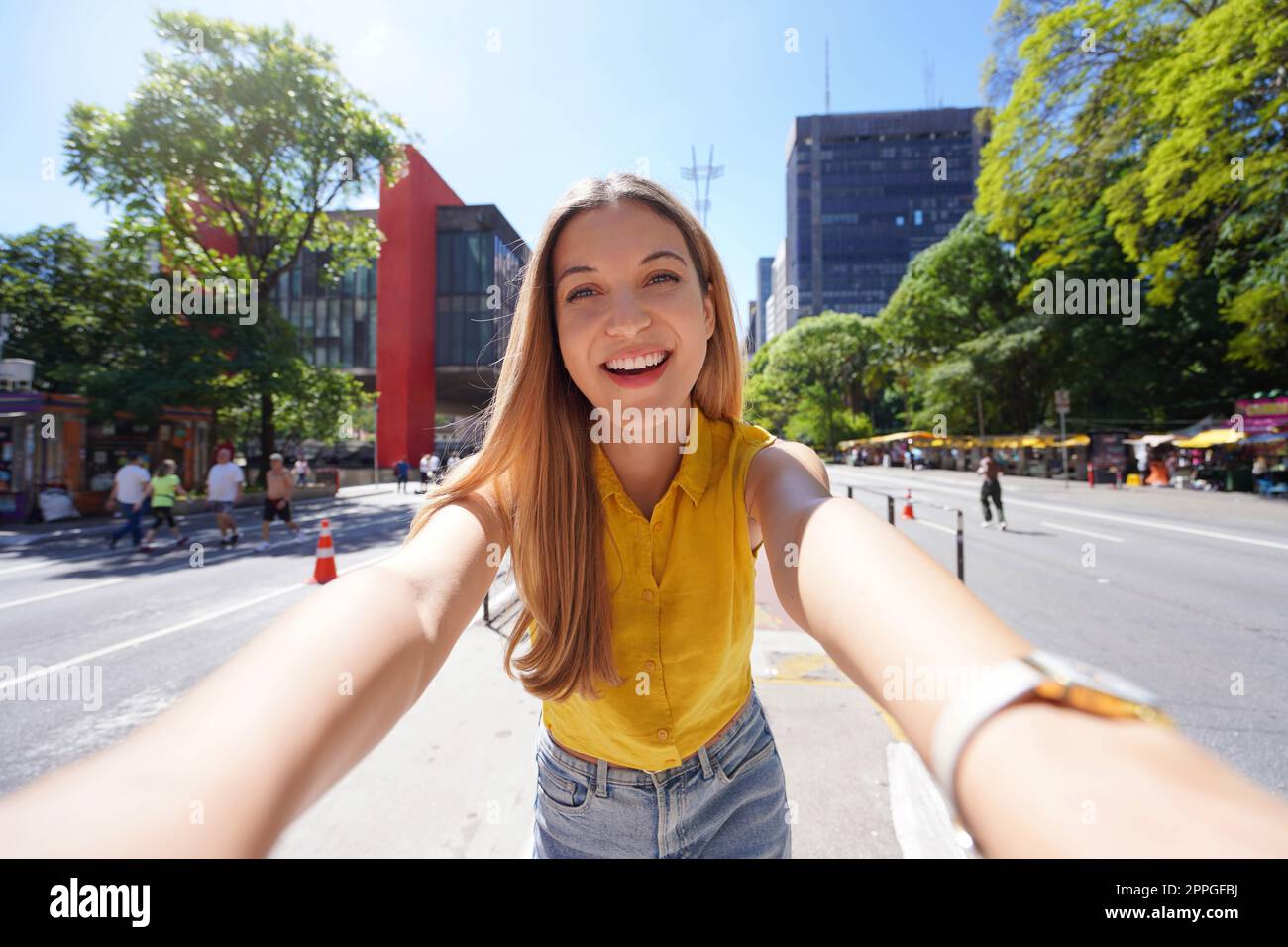 Tourism in Sao Paulo. Beautiful smiling girl takes self portrait on Paulista Avenue, Sao Paulo, Brazil. Stock Photo