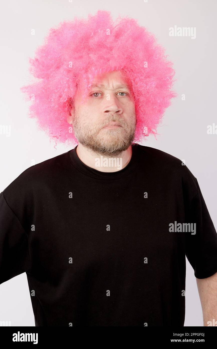 angry man with pink afro wig Stock Photo