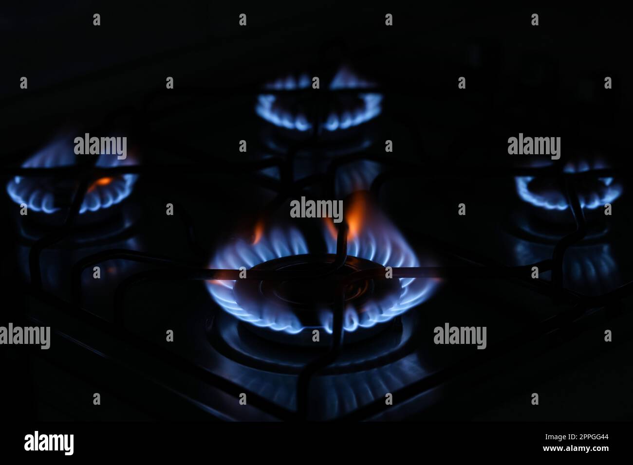 Gas cooktop with burning blue flames in darkness Stock Photo Alamy