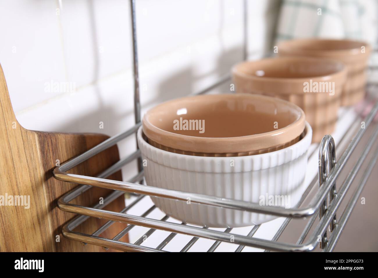 Many different ramekins on metal rack in kitchen, closeup Stock Photo